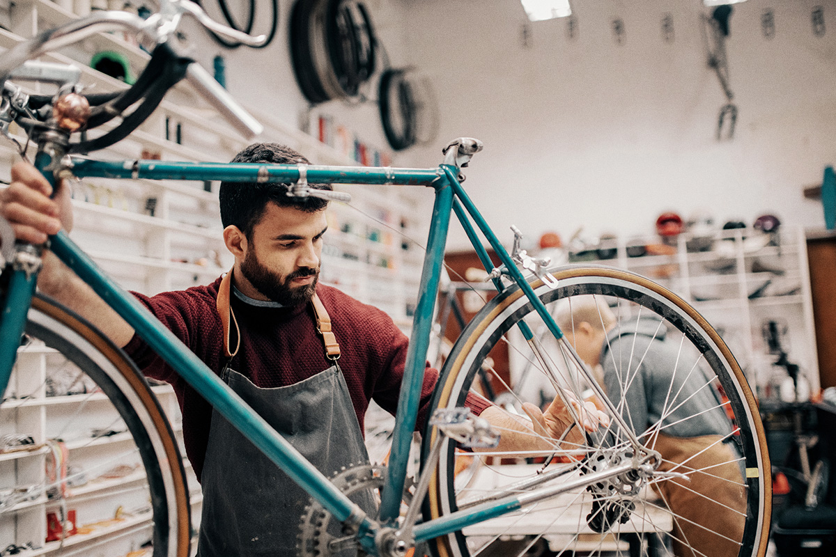 bearded man working in bike shop